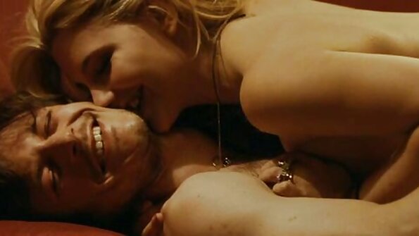 சோபாவில் ஒரு பெரிய மெல்ல உணர்கையில், பெரிய டைட்டுகளைக் கொண்ட ஒரு பொன்னிறம்