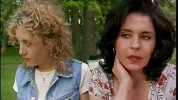 ஒரு காகம் கூந்தல் பெண் படுக்கையில் ஒரு நீண்ட பெக்கரை உறிஞ்சுகிறாள்